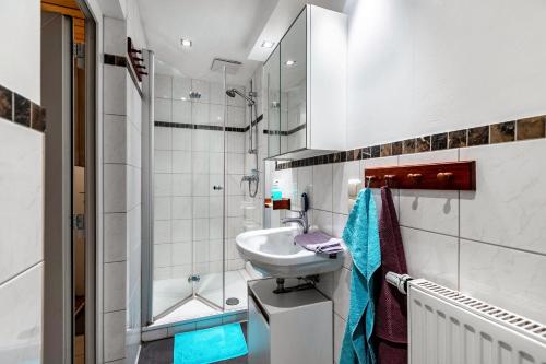 une salle de bain blanche avec un lavabo et une douche dans l'établissement Hof Islandpferde von der Holstenau, à Eggstedt