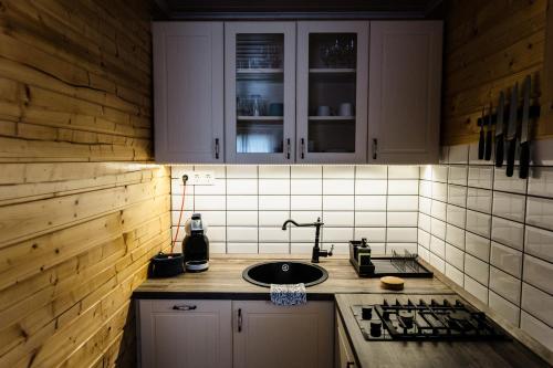 a kitchen with white cabinets and a sink at Zegzug Noszvaj in Noszvaj