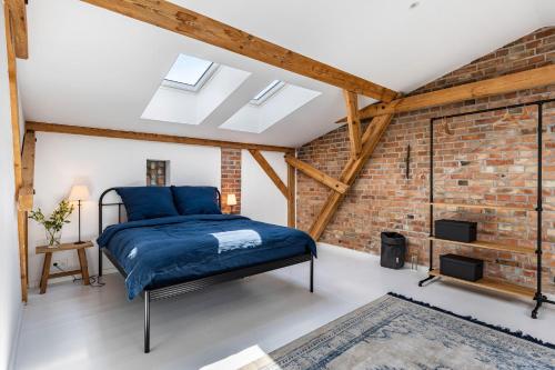 a bedroom with a brick wall and a blue bed at Ferienwohnung im Pferdestall in Angermünde