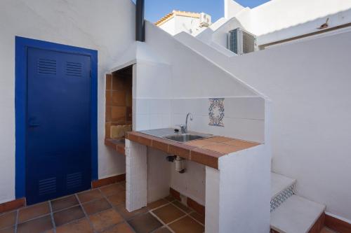 La salle de bains est pourvue d'un lavabo et d'une porte bleue. dans l'établissement Casa Marítima Mediterránea, à El Verger