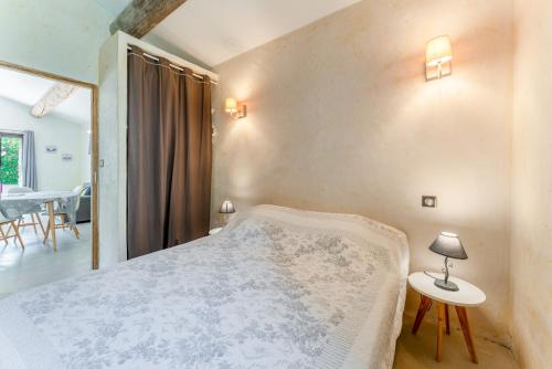 a bedroom with a bed and a table with a lamp at Bergeries Saumane, Petite Bergerie in Saumane-de-Vaucluse