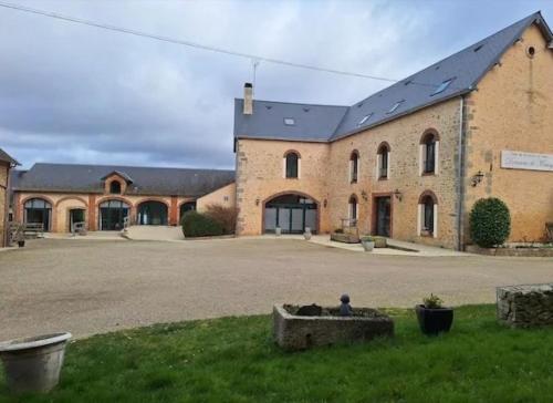 a large brick building with a person sitting in front of it at Domaine de Meslay in Fyé