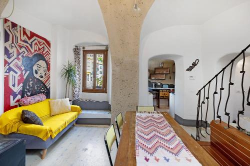 a living room with a yellow couch and a table at Casa Gecko in Tovo San Giacomo