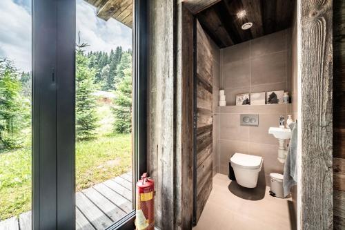 a bathroom with a toilet and a sliding glass door at Chalet Bella in Essert-Romand
