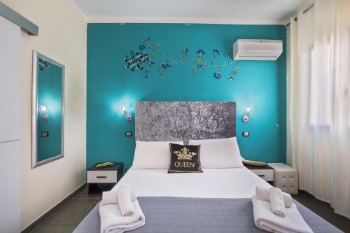 Un dormitorio con una cama con una pared azul. en Elysium Luxe Suites, en Porto Cesareo