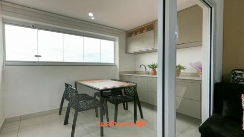 a kitchen with a table and chairs in a room at Apartamento em Bauru com Vista para Montanha in Bauru