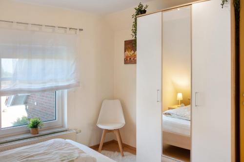 a bedroom with a closet and a bed and a window at Gina´s Lüttje Ferienwohnung in Nenndorf