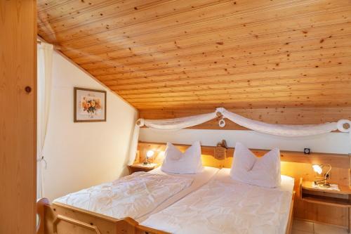 une chambre avec un lit avec un plafond en bois dans l'établissement Ferienhaus St Christoph, à Mittenwald