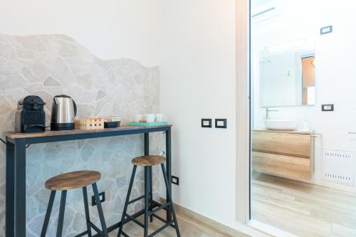 cocina con encimera y 2 taburetes en La Dimora in Città, en Stazione Bari Centrale