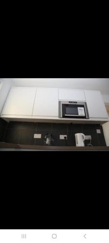 a counter top with a microwave on top of it at BUDGET Small Rooms in Thamesmead