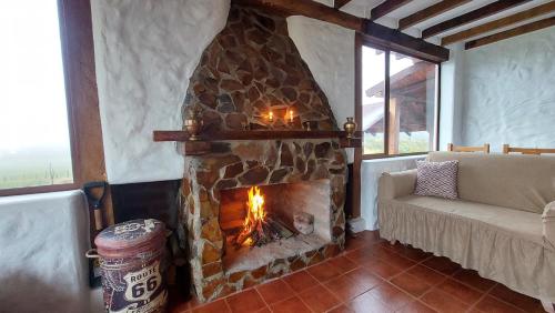 ein Steinkamin in einem Wohnzimmer mit einer Couch in der Unterkunft Cotopaxi Lodge in Hacienda Porvenir