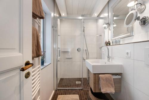 a small bathroom with a sink and a shower at Hyggelig Am Deich - Ockholm in Ockholm