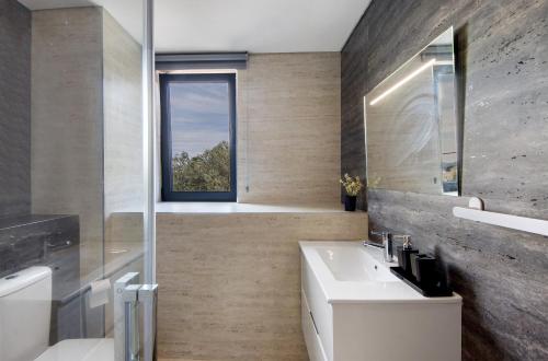 ein Badezimmer mit weißem Waschbecken und Fenster in der Unterkunft Quinta de Ramil in Rossas