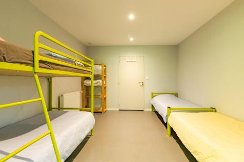 ヴィトラックにあるGite l'Ecurie de l'Etrierの二段ベッド2台とドアが備わる客室です。