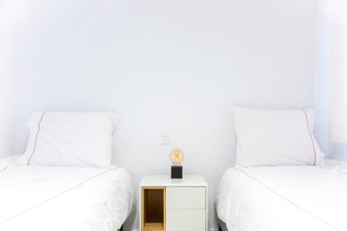 two beds in a room with white walls at Calpe Bay in Calpe