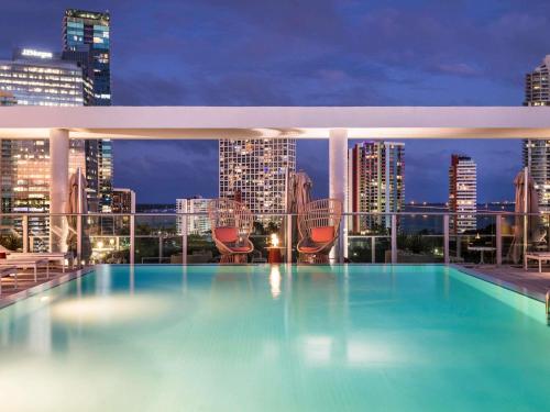 a swimming pool on the roof of a building with a city skyline at Novotel Miami Brickell in Miami