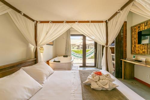 a bedroom with a bed with a tub and a sink at Pousada Rosa 08 - Café da manhã Gourmet, Suítes com Banheira a 150m do Centrinho da Praia do Rosa in Praia do Rosa