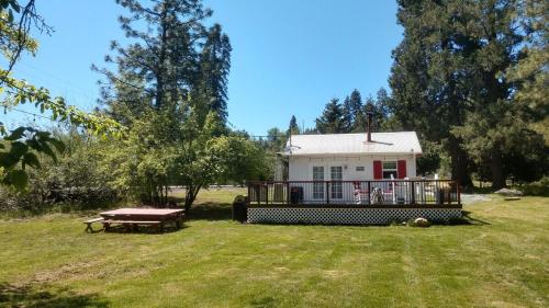 a house in a field with a picnic table at Meadow Creek Cabin in Camino