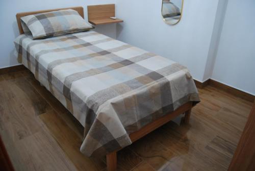 uma cama num quarto com um cobertor xadrez em The White House em Mercato San Severino
