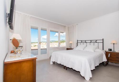 ein weißes Schlafzimmer mit einem Bett und einem Fenster in der Unterkunft Villa Berganti in Canet de Mar