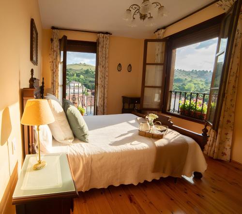 a bedroom with a bed and a large window at Casa Rural Chanin 1 - 2 in Pinilla de los Barruecos