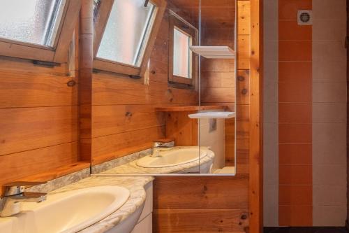 ein Badezimmer mit zwei Waschbecken und einem Spiegel in der Unterkunft Chalet Orange - Piscine Partagée in Darbres