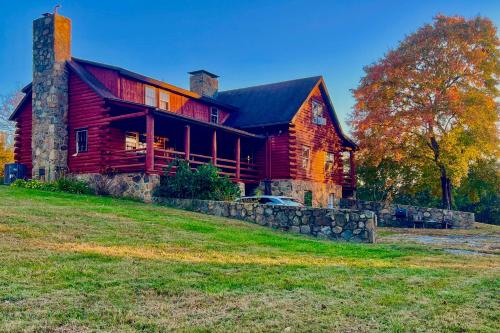 a large red barn with a car parked in front of it at Cozy Log Cabin Getaway with Fire Pit and 3 Acres! in Ruckersville