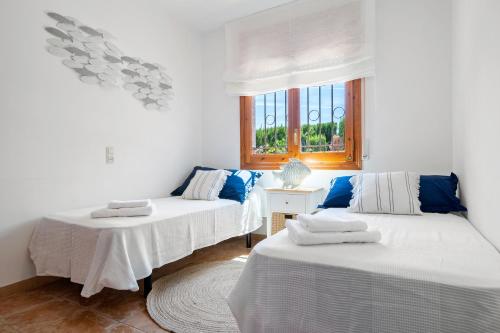 a room with two beds and a window at Chalet a pie Cala Forn con piscina in Les tres Cales