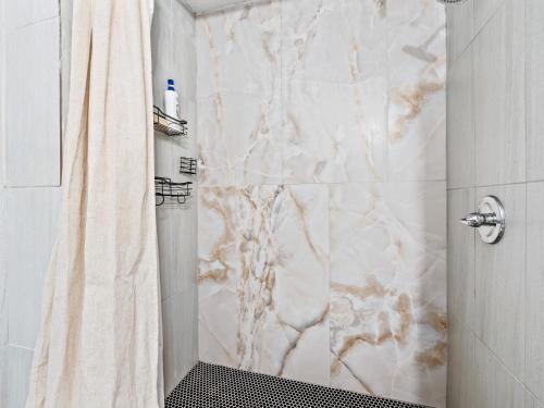 a bathroom with a marble shower with a shower curtain at 4brping Pong2500 Sq Ft in Bedford