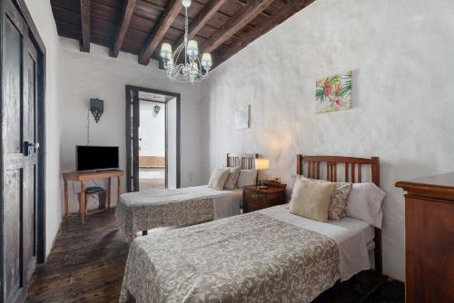 a hotel room with two beds and a television at La Tunera in La Cisnera