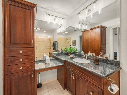 Un baño con dos lavabos y un espejo grande. en Westminster Retreat 2 King Bed, Pool, Game Room, en Richardson