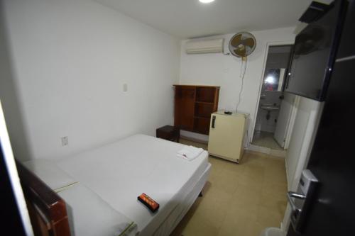 a small bedroom with a bed and a refrigerator at Hotel Nuevo Tio in Valledupar
