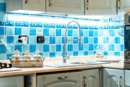 コスタ・レイにあるVilla Tizianaの青いタイルの壁、シンク付きのキッチン