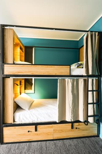 two bunk beds in a room with a bed at Crashpalace Napier in Napier