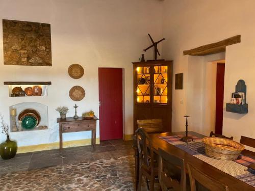 a dining room with a table and a cross on the wall at Herdade Da Carapuça in Portalegre
