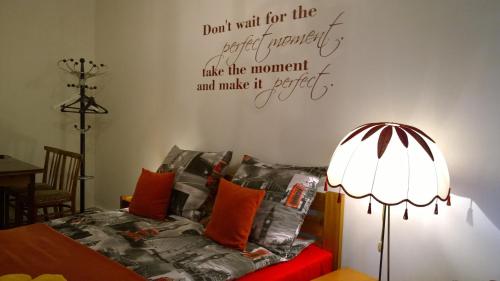 a bedroom with a bed with a lamp and words on the wall at Apartament w Krakowie in Kraków