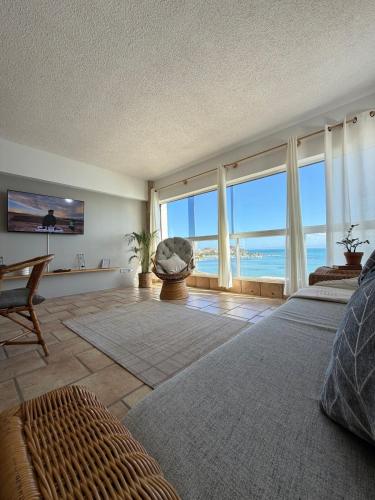 a living room with a view of the ocean at Mar & Relax, apartamento en primera linea de playa in Porlamar