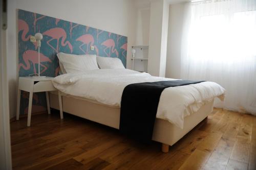 a bedroom with a bed with a pink flamingos wallpaper at The View Boutique Apartments in Ohrid