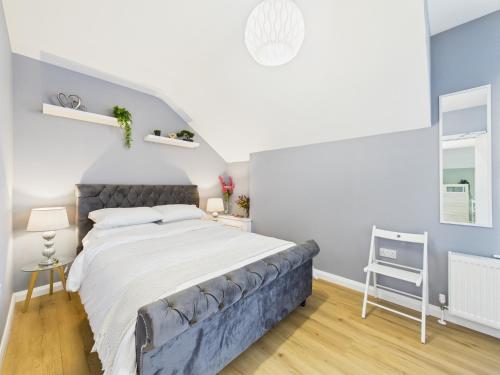 ein Schlafzimmer mit einem großen Bett mit blauem Kopfteil in der Unterkunft Kings Corner in Warrenpoint