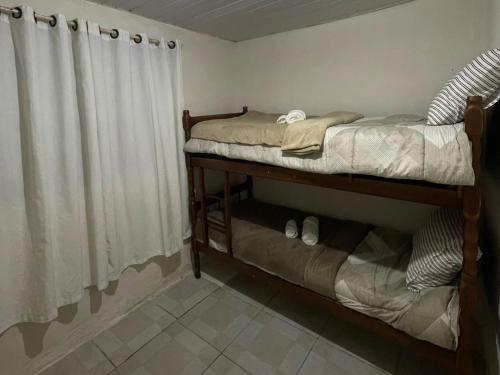a bedroom with two bunk beds and a curtain at Casa térreo in São José dos Pinhais