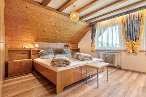 a bedroom with a large bed in a wooden room at Gästehaus Gerda in Bad Peterstal-Griesbach
