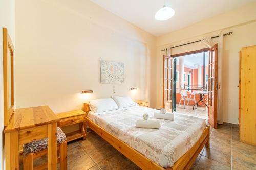 een slaapkamer met een bed, een bureau en een raam bij Arianna apartment 14 in Paleokastritsa