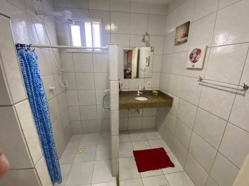 Un baño blanco con lavabo y ducha. en Vila dos Ventos - RedeVilla, en Estância