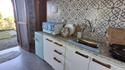 a kitchen with a sink and a counter top at Suíte Coqueiros Paraty in Paraty