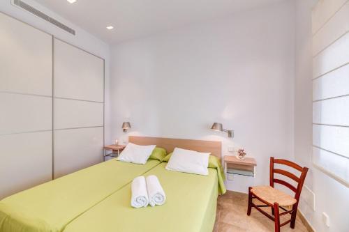 a bedroom with a green bed and a chair at Es Pop Nou in Sa Ràpita