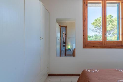 a white room with a mirror and a bed at Reysol Home in Agnone Bagni
