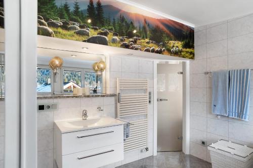 a bathroom with a sink and a picture of sheep at Haus Riedel in Garmisch-Partenkirchen