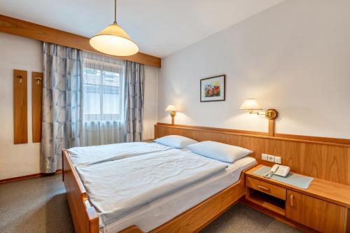 a bedroom with a large bed and a table at Taufner Apartement B 104 in Parcines