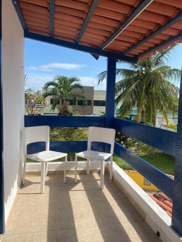 Sol Mar Hostel في Santo Agostinho: كرسيين على بلكونه فيها نخل