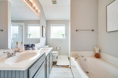 a bathroom with two sinks and a tub and a toilet at King Bdgame Roomprivate Lake Access in Little Elm